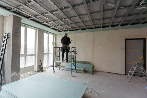 Modern gipszkarton álmennyezet szakszerű kivitelezése állványról egy budapesti lakásfelújítás során – a Bízd Ránk Lakásfelújítás 2026 precíz belsőépítészeti munkája.